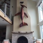 Giant Cedar Whale Sculpture with First Breath Baby Whale is mounted High Above the Fireplace Spanning 2 Stories