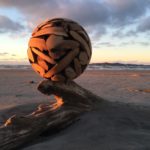 Driftwood Sphere Sculpture is Shown on the Beach at Sunset and Highlights the Grain of the 3ft Carving